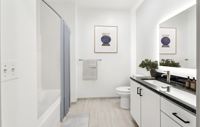 A bathroom with a toilet, sink, and a mirror.