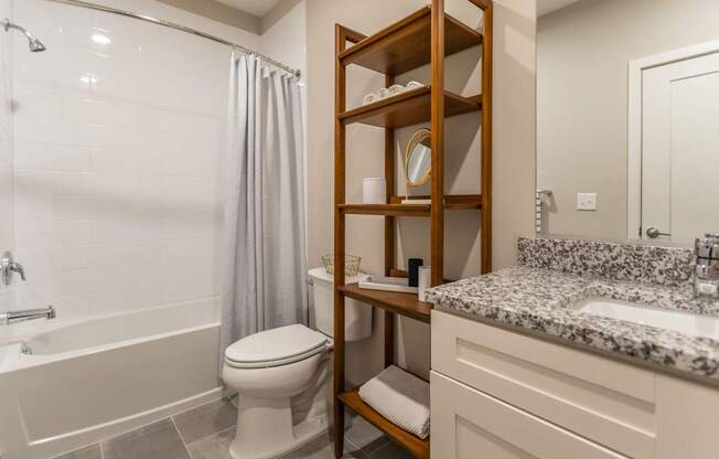 A bathroom with a toilet, sink, and shower.