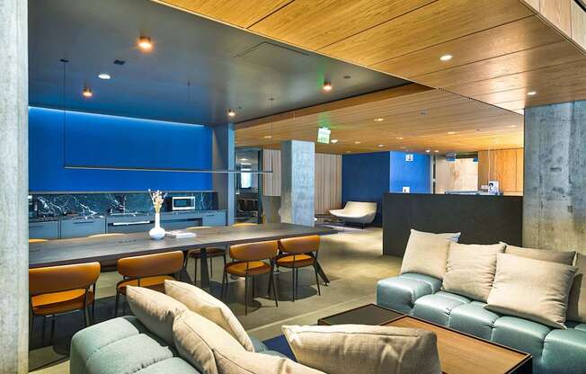 A modern living room with a blue accent wall and a wooden ceiling.