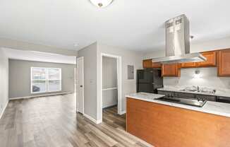 A kitchen with a stainless steel range hood and wooden cabinets.