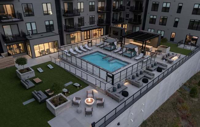 A large outdoor pool surrounded by lounge chairs and umbrellas.