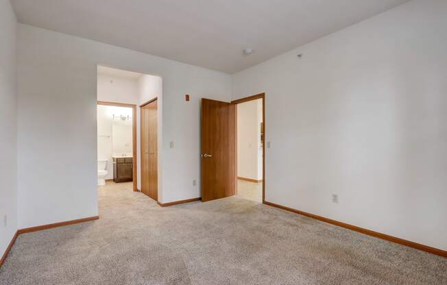 a living room with carpet and a door to a bathroom