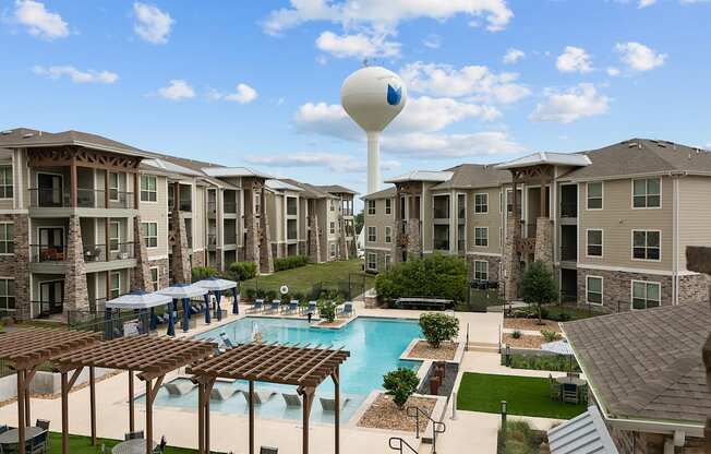 an aerial view of an apartment complex with a pool and water tower