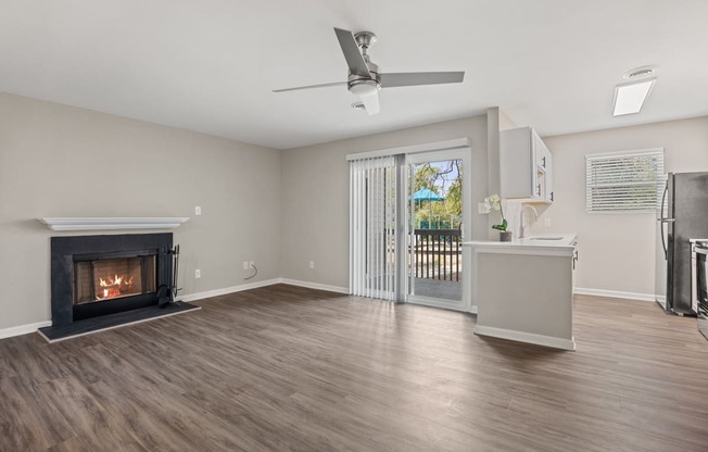 a living room with a fireplace and a door to a balcony