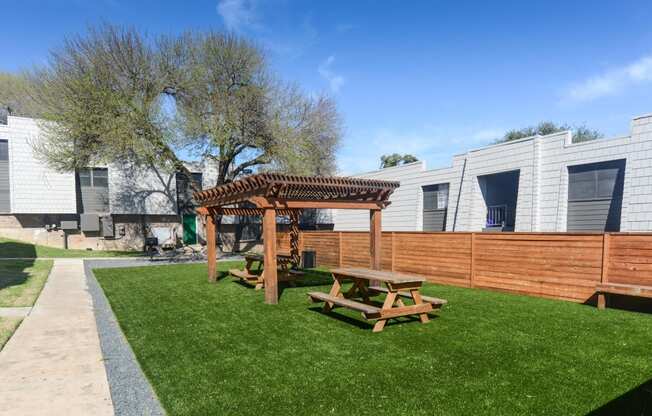 a backyard with a picnic table and a wooden fence