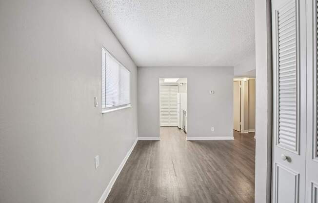 A room with a white door and a window with blinds.