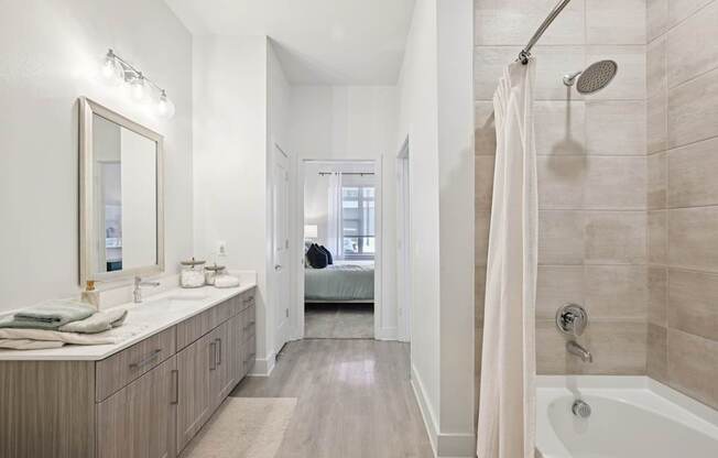 A bathroom with a white tub, sink, and shower.