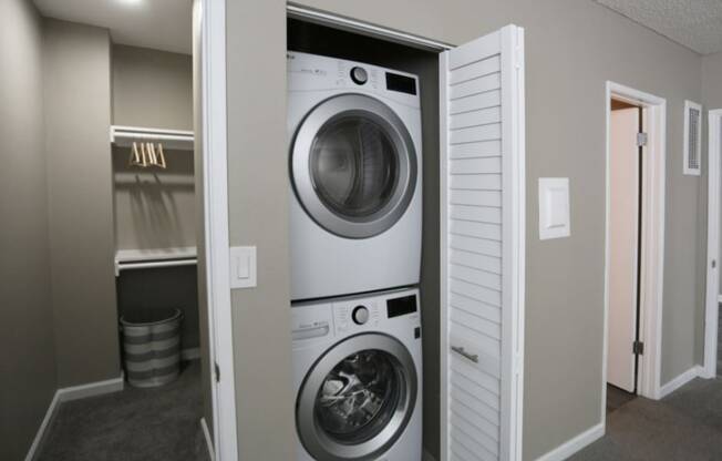 A white washing machine is in a small laundry room.