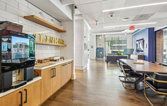 a dining room with a table and chairs and a coffee machine at Link Apartments Innovation Quarter, Winston Salem, 27101