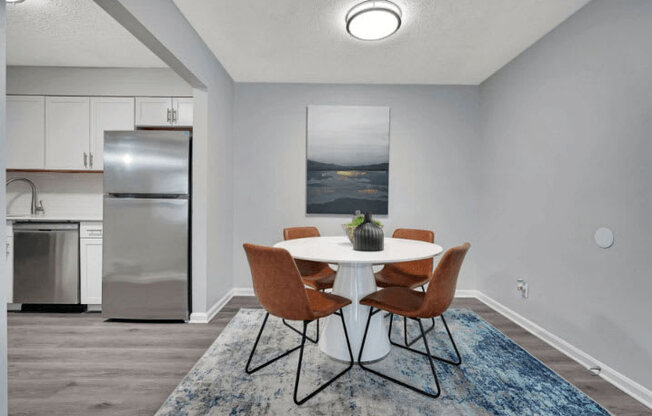 a dining room with a table and chairs and a refrigerator in the background at Enclave at Breckenridge Apartments, Louisville, 40220