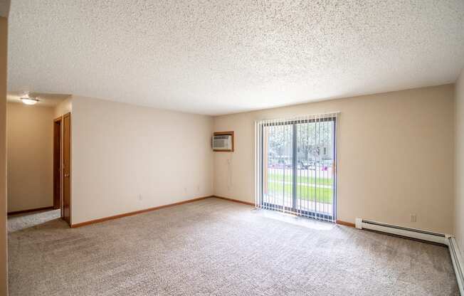 Bismarck, ND Eastbrook Apartments. A spacious living room with a sliding glass door leading to a yard