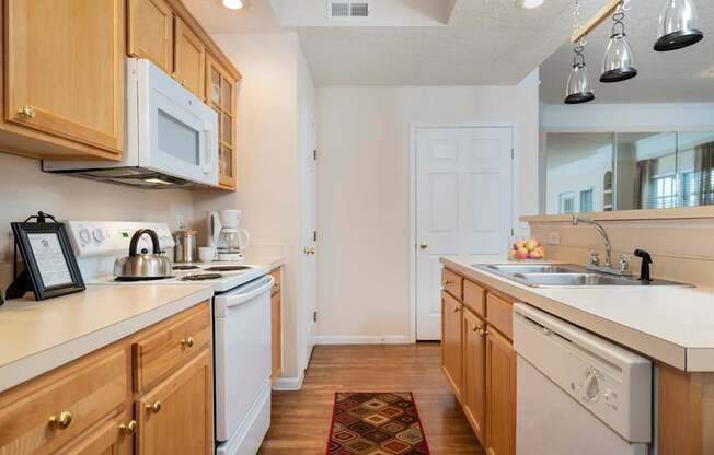 A kitchen with wooden cabinets and white appliances. at The Orchard, Ohio, 43016