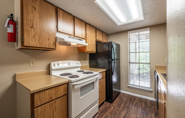 A kitchen with a white stove and black refrigerator.