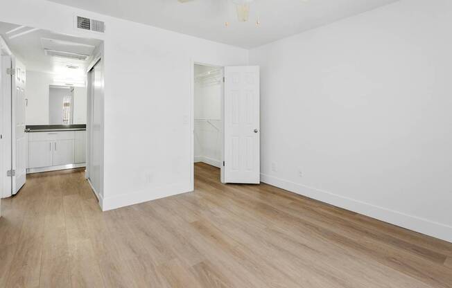 A room with a white door and a white ceiling fan.