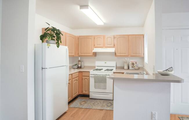 a renovated kitchen with white appliances and wooden cabinets