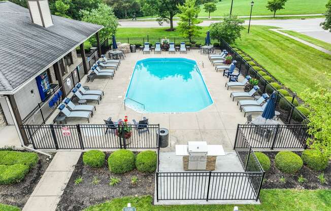 an aerial view of a resort style swimming pool with lounge chairs and umbrellas