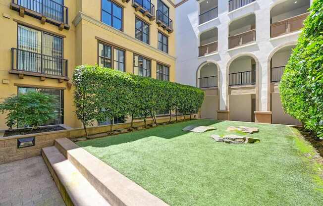 A well-maintained lawn in front of a building with balconies.