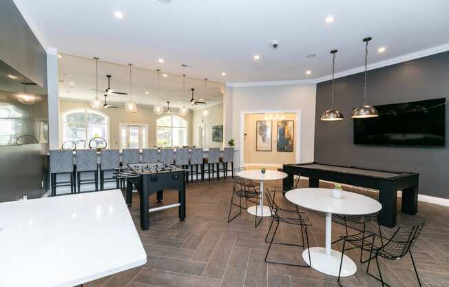 a game room with tables and chairs and a television  at Deerfield Village, Alpharetta, Georgia