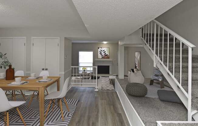 a living room and dining room with a staircase