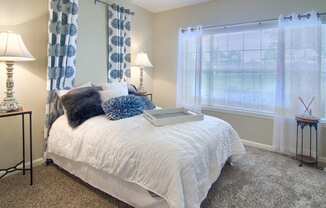 Enclave at Wolfchase Apartments in Cordova Tennessee photo of a bedroom with a bed and two windows