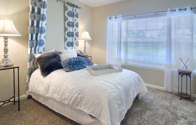 Enclave at Wolfchase Apartments in Cordova Tennessee photo of a bedroom with a bed and two windows