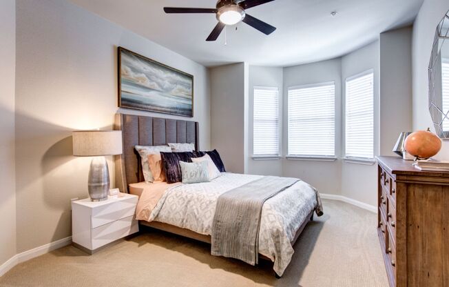 a bedroom with a bed and a ceiling fan