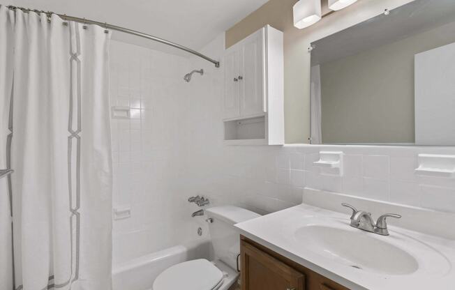a white bathroom with a shower sink and toilet