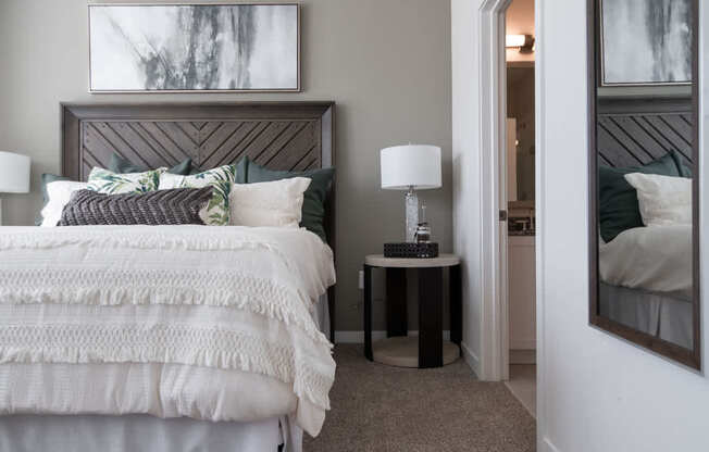 a bedroom with a bed and a nightstand with a lamp