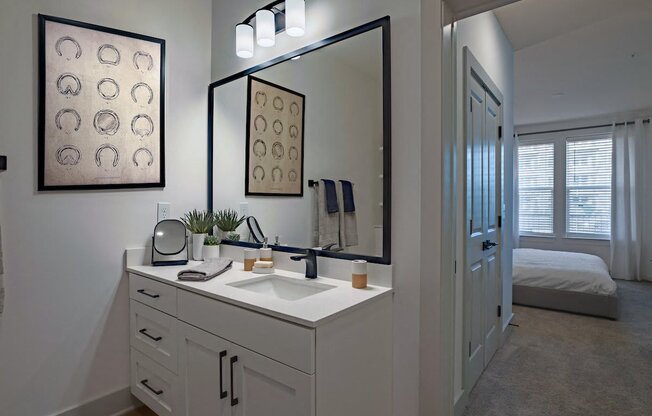 a white bathroom with a large mirror and a sink