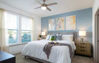 a bedroom with a large bed and a ceiling fan