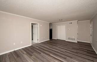 A room with wood flooring and white walls.