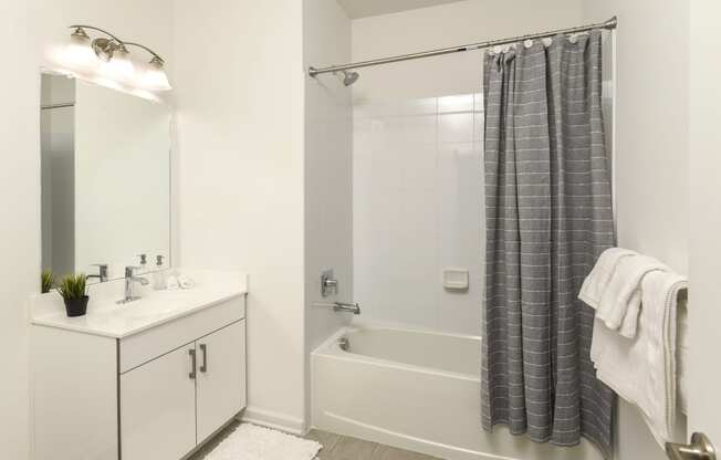 a bathroom with a shower and a sink and a mirror