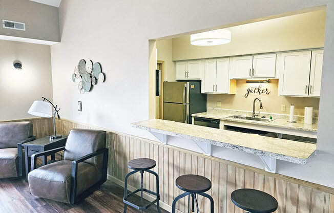 Clubhouse kitchen with a bar and stools