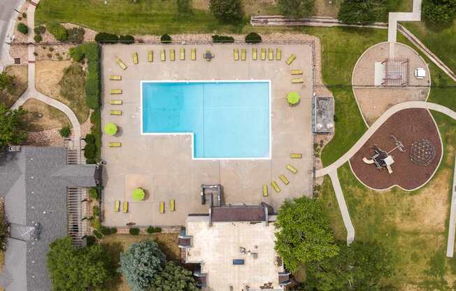 a birds eye view of a swimming pool in the middle of a yard with a