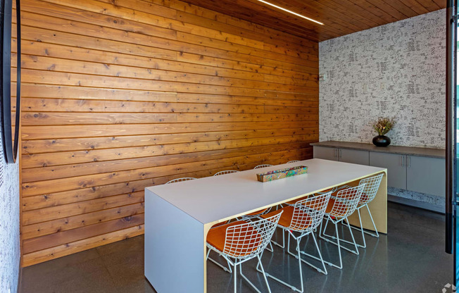 a long white conference table in a room with wooden walls