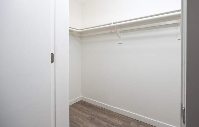 an empty room with white walls and a wood floor