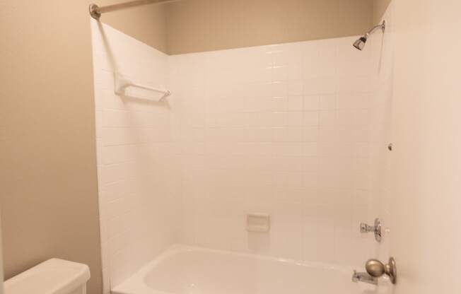 View of tiled tub shower combo in bathroom