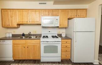 A kitchen with wooden cabinets and white appliances.