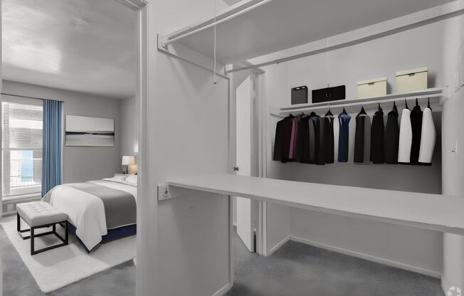 a bedroom with a bed and a closet with a rack of clothes