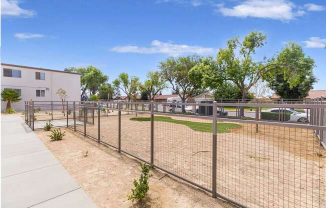 A fenced area with a building in the background.