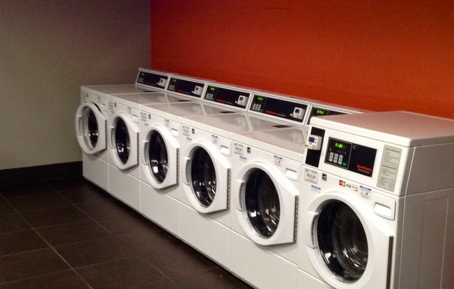 a row of washing machines and dryers in a laundromat