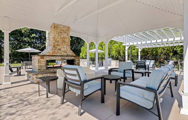 the outdoor patio has a fireplace and tables with chairs at View at Lake Lynn, Raleigh, NC 27613