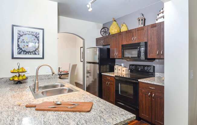 Spacious kitchen featuring stainless steel appliances, granite countertops, and white cabinetry.