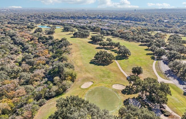 A golf course surrounded by trees.