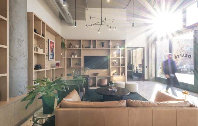 a living room with couches and chairs and a large window at The Draper, St Louis, MO, 63103