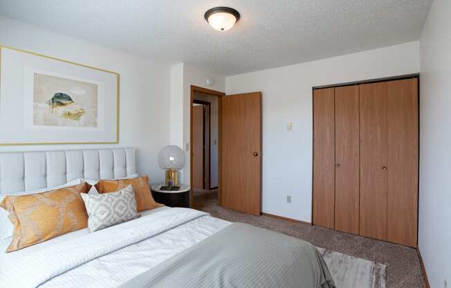 a bedroom with a bed and a closet. Fargo, ND Westview Towers Apartments