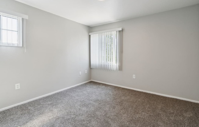 an empty room with carpet and a window