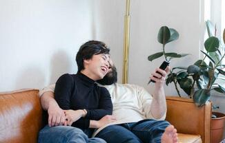 a man sitting on a couch looking at his cell phone