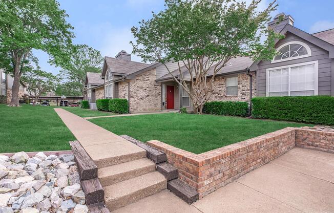 a stone building that has grass in front of a house