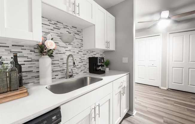 a kitchen with white cabinets and a sink1 at Town & Country Apartments - Wixom, MI, Wixom